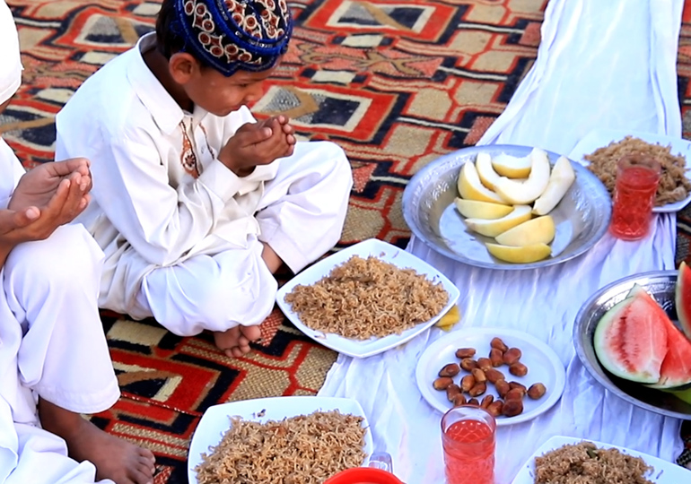 children making a prayer while having iftar